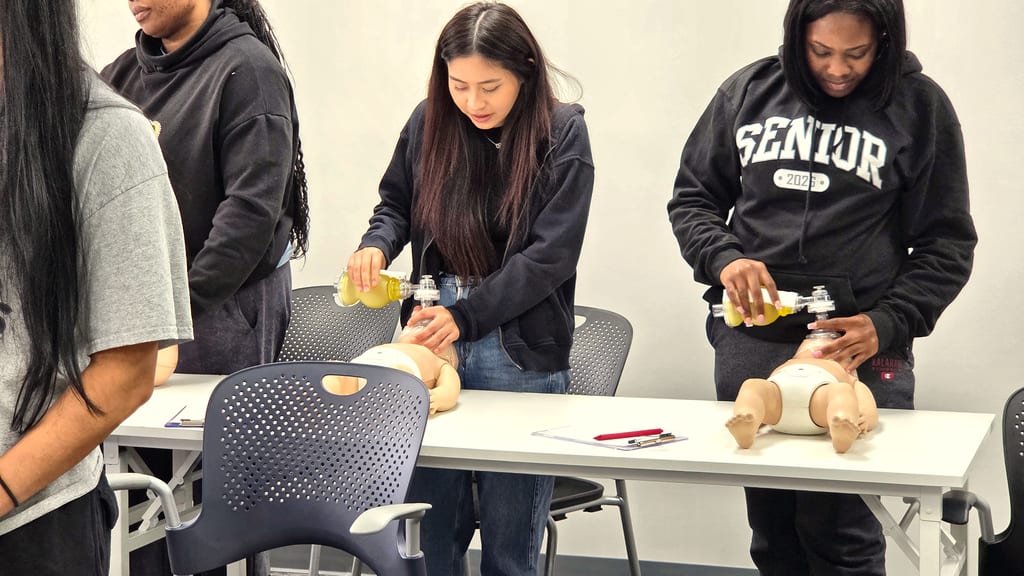 Cardiox Care instructor guiding hands-on CPR practice in a Houston classroom.