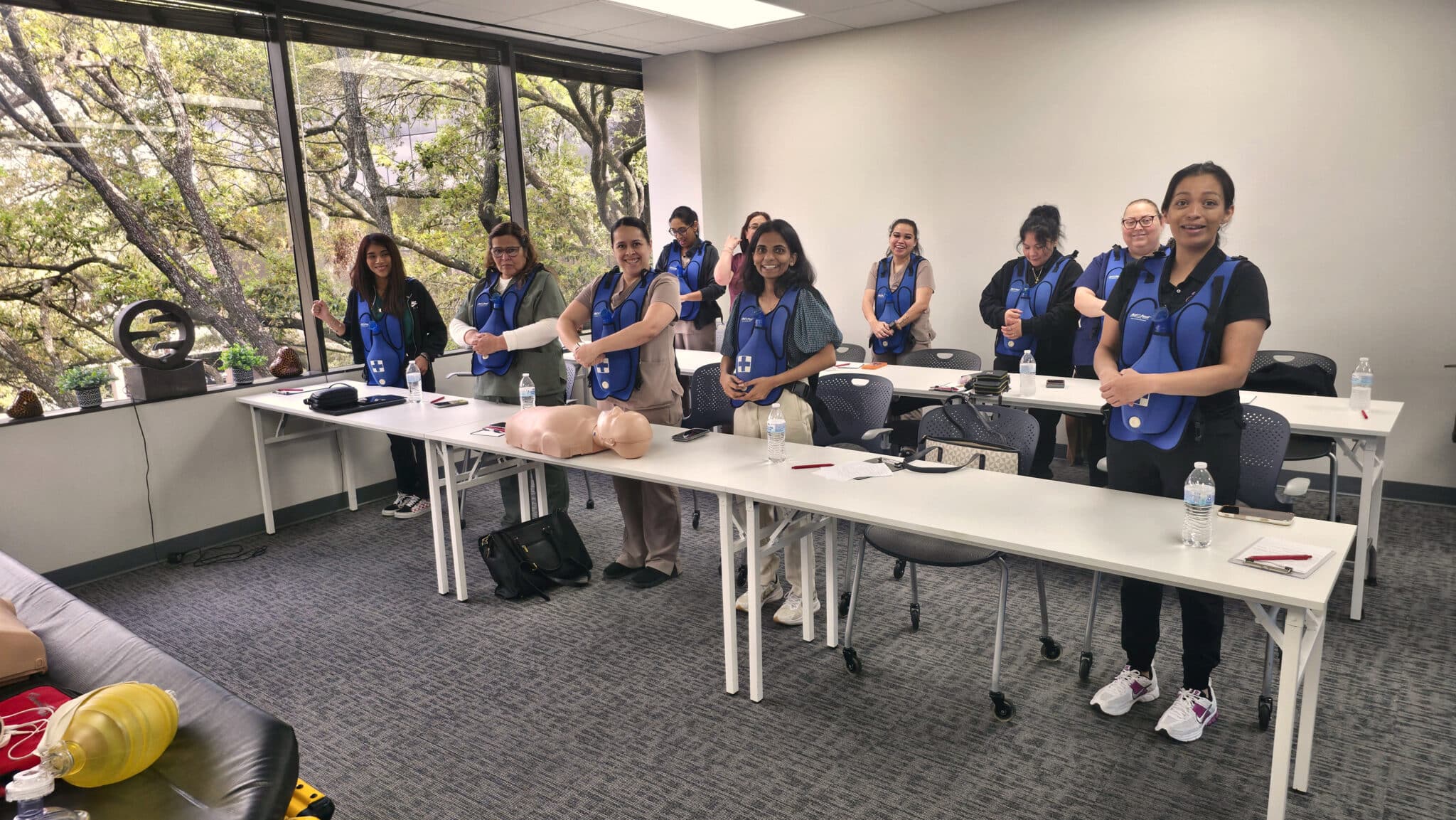Team practicing CPR on training manikins during a Cardiox Care group class