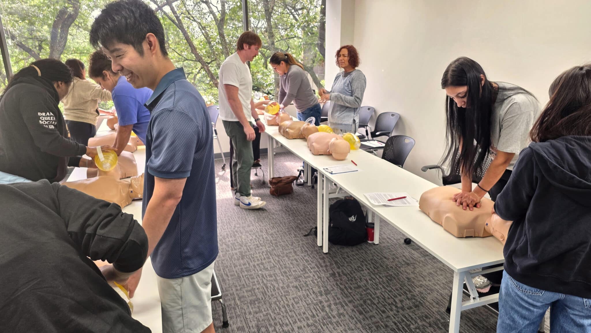 Students performing two-person rescue CPR on adult manikins during Cardiox Care BLS training