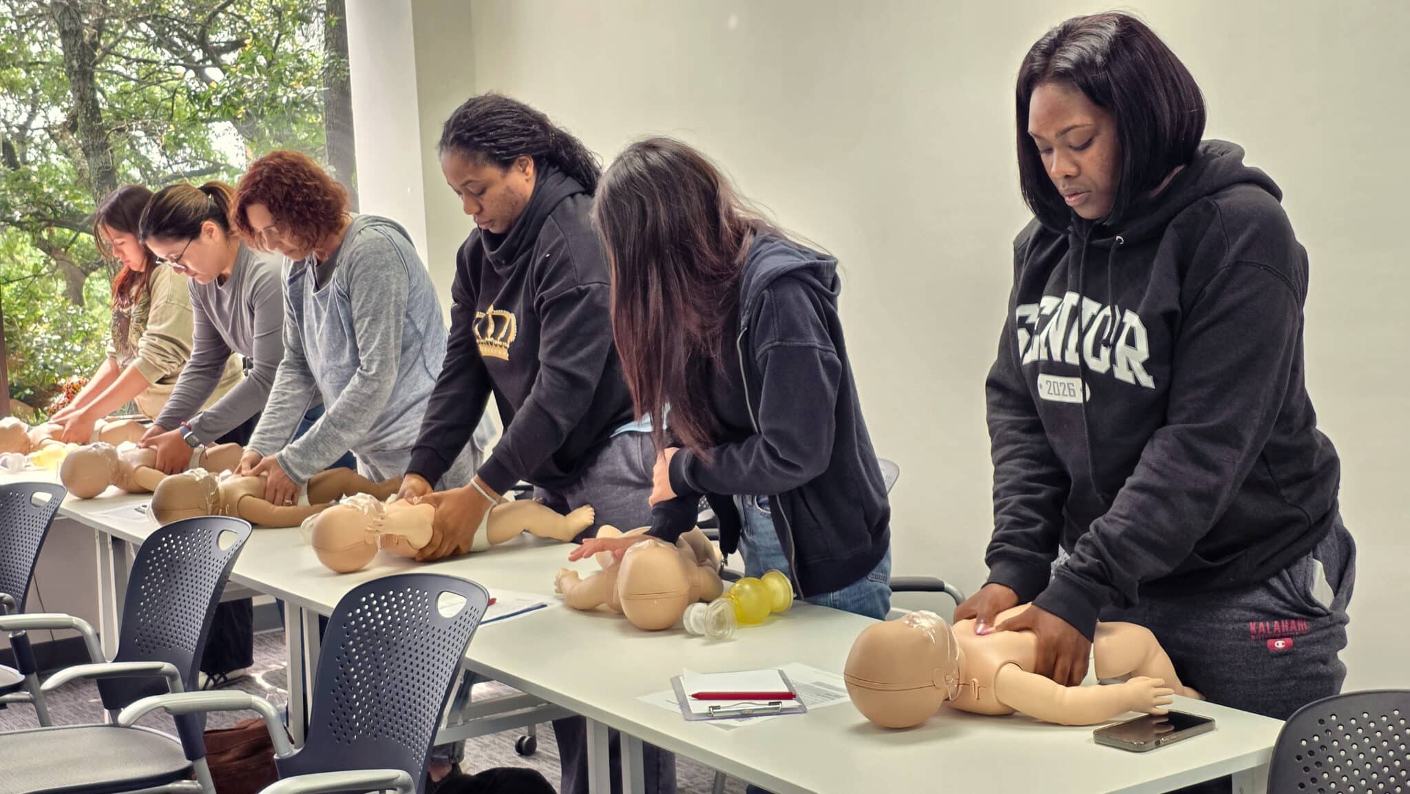 Students practicing one-person infant CPR during a hands-on Cardiox Care CPR class